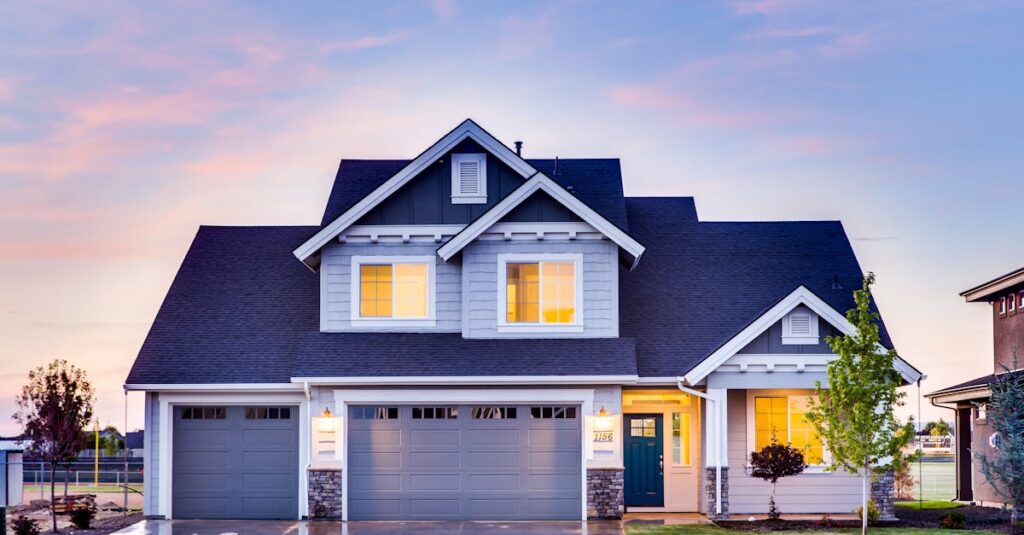 Beautiful two-story house with illuminated windows and garage at dusk.
